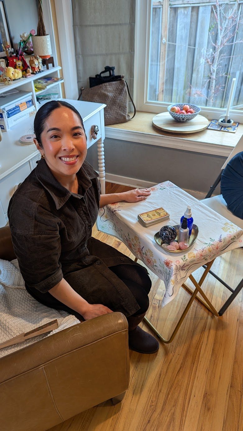 Charlene reading tarot at a small table with crystals during a private vision board party