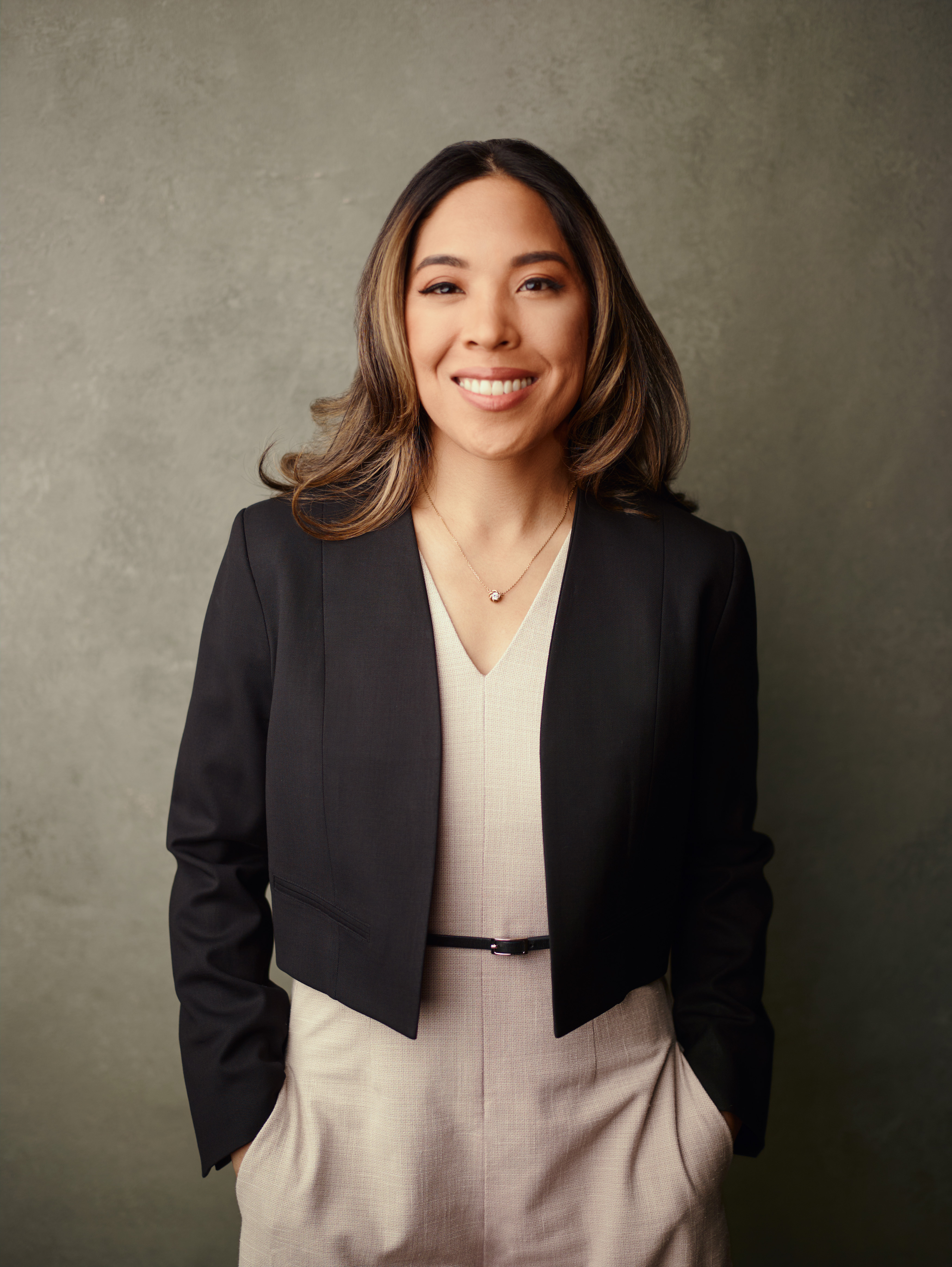 Charlene Platon smiling in a dark blazer, professional studio portrait